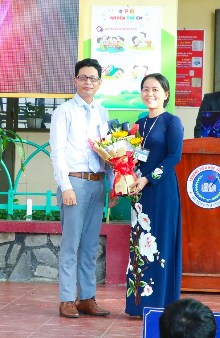 Thầy Nguyễn Huy Thành - Giám đốc Trung tâm Ngoại ngữ Phát triển Việt Mỹ trao tặng hoa lưu niệm cho Cô Nguyễn Thị Thu - Hiệu trưởng trường Tiểu học Vĩnh Lộc 2